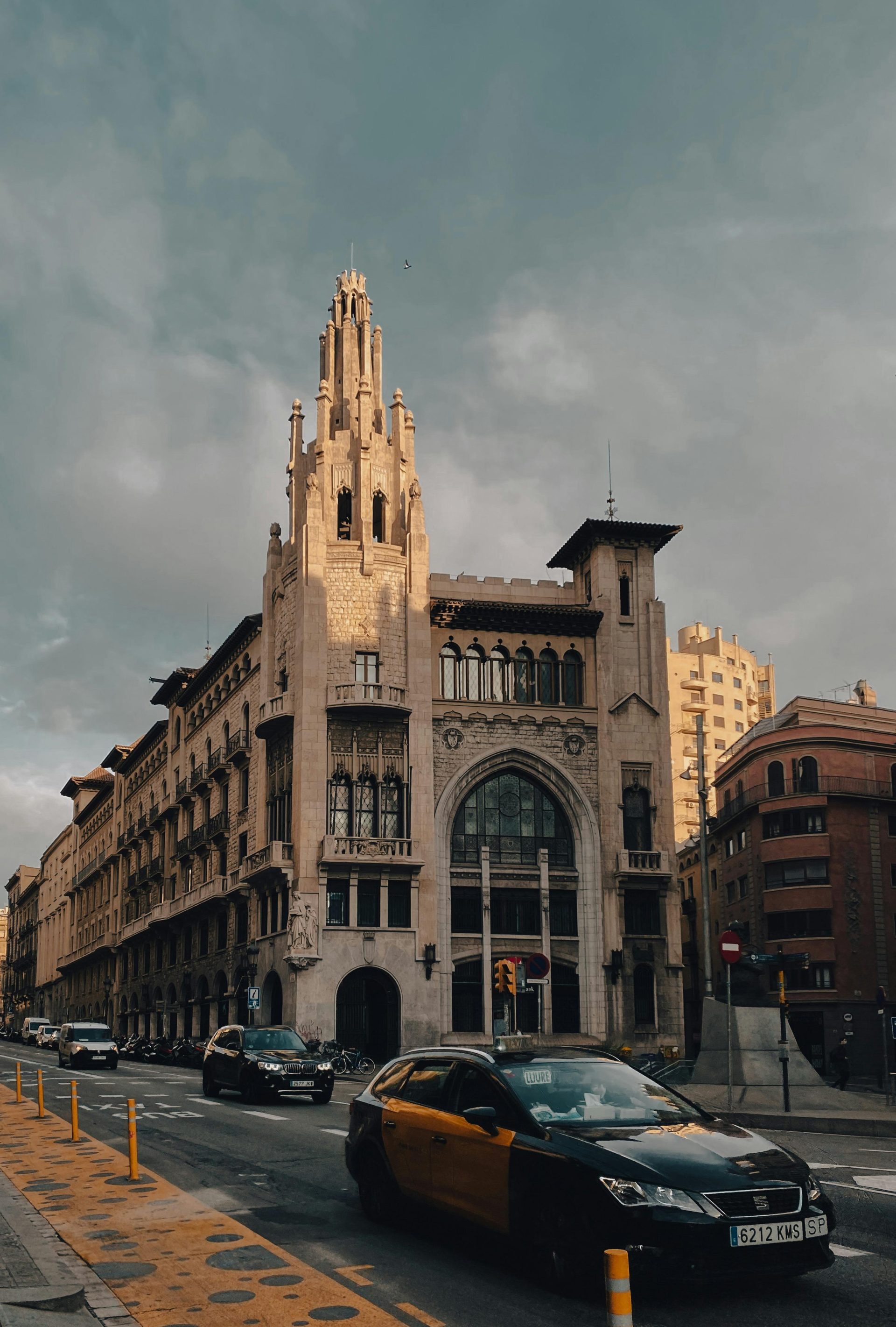 Un impresionante edificio de estilo gótico en Via Laietana, Barcelona, ​​con una animada vida callejera.